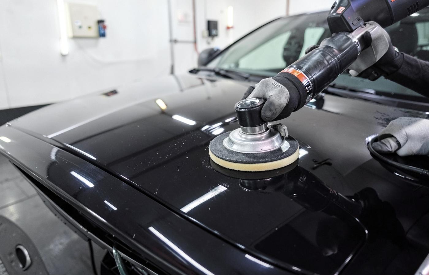 Machine polishing the hood of a dark car during detailing in Bethlehem, PA