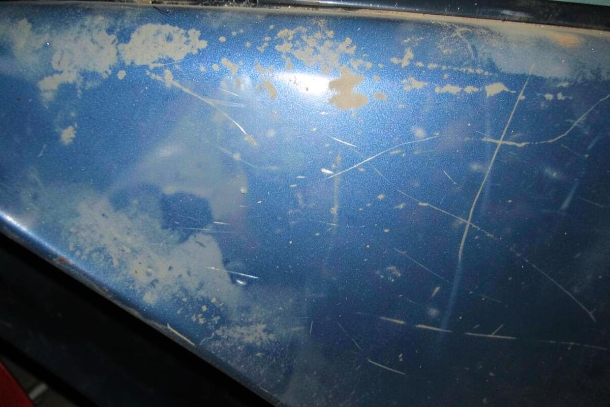 Faded, oxidized and scratched blue car paint before refinishing